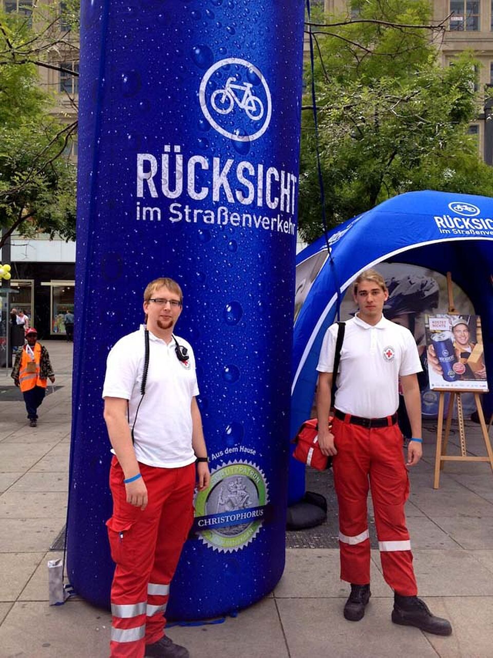 Zwei Sanitäter vor einem Infostand