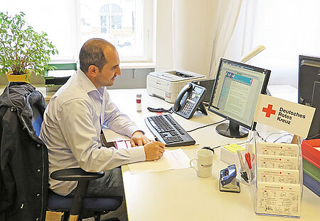 Mohamad Naim bearbeitet einen Stiftungsantrag. Foto: Jessica Karbon / DRK