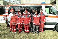 Gruppenbild der Sanitäter vor einem Rettungswagen